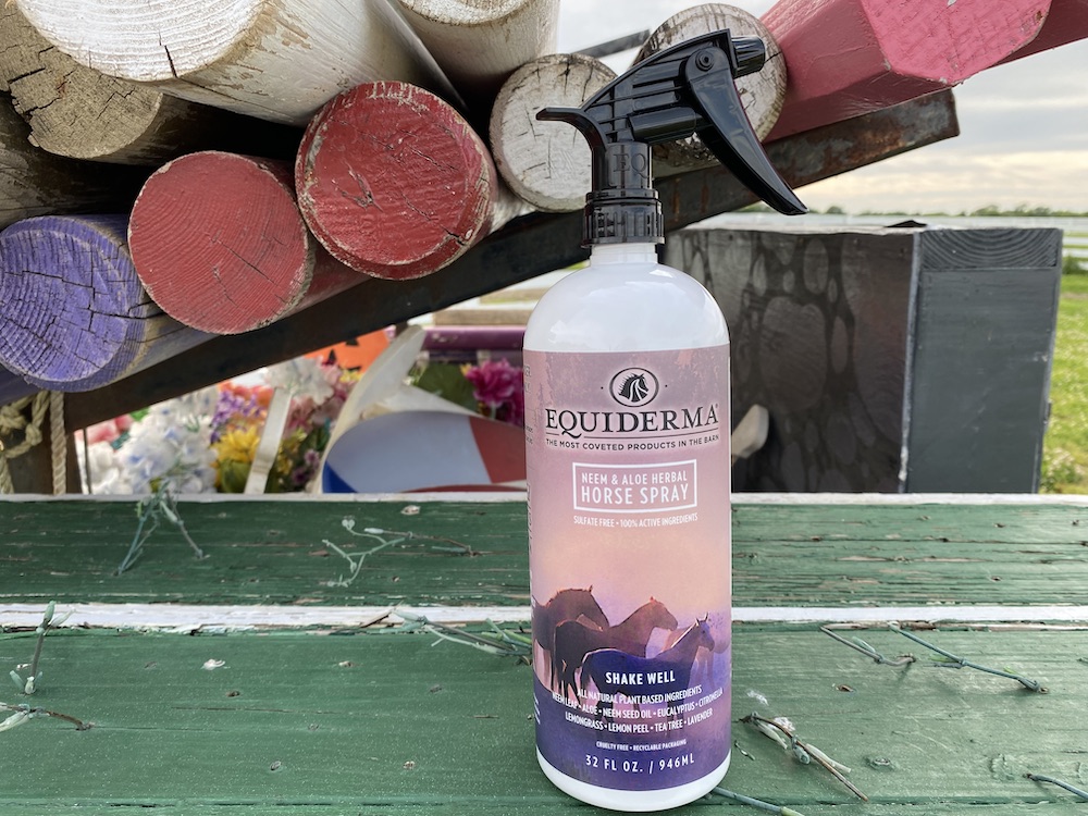 Equiderma natural fly spray for horses resting on a horse jump.