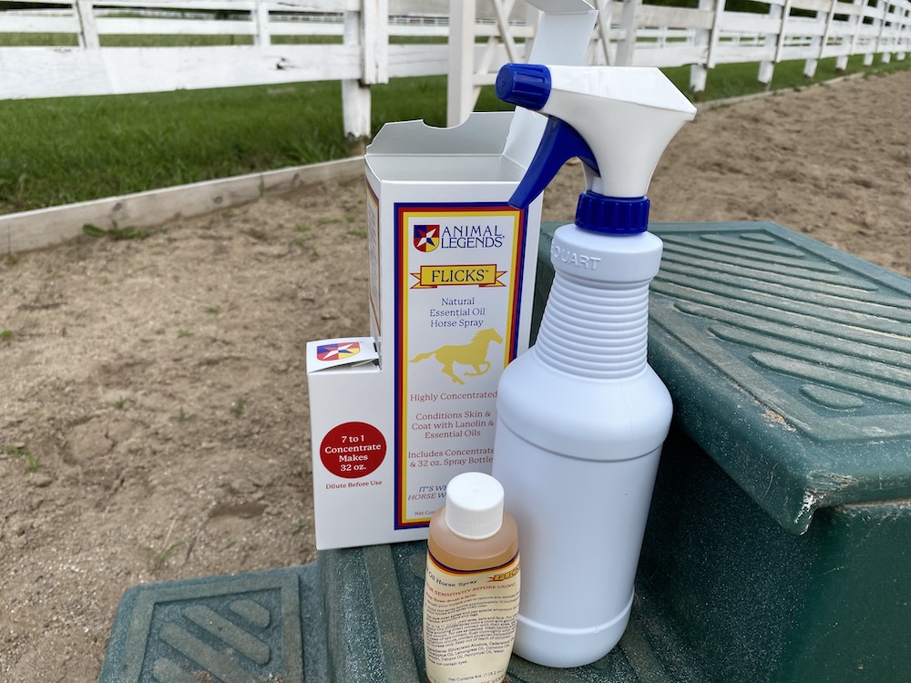 Flicks natural fly spray for horses on a mounting block. Animal Legends sends the empty spray bottle and a tiny bottle with the formula you dilute in water.