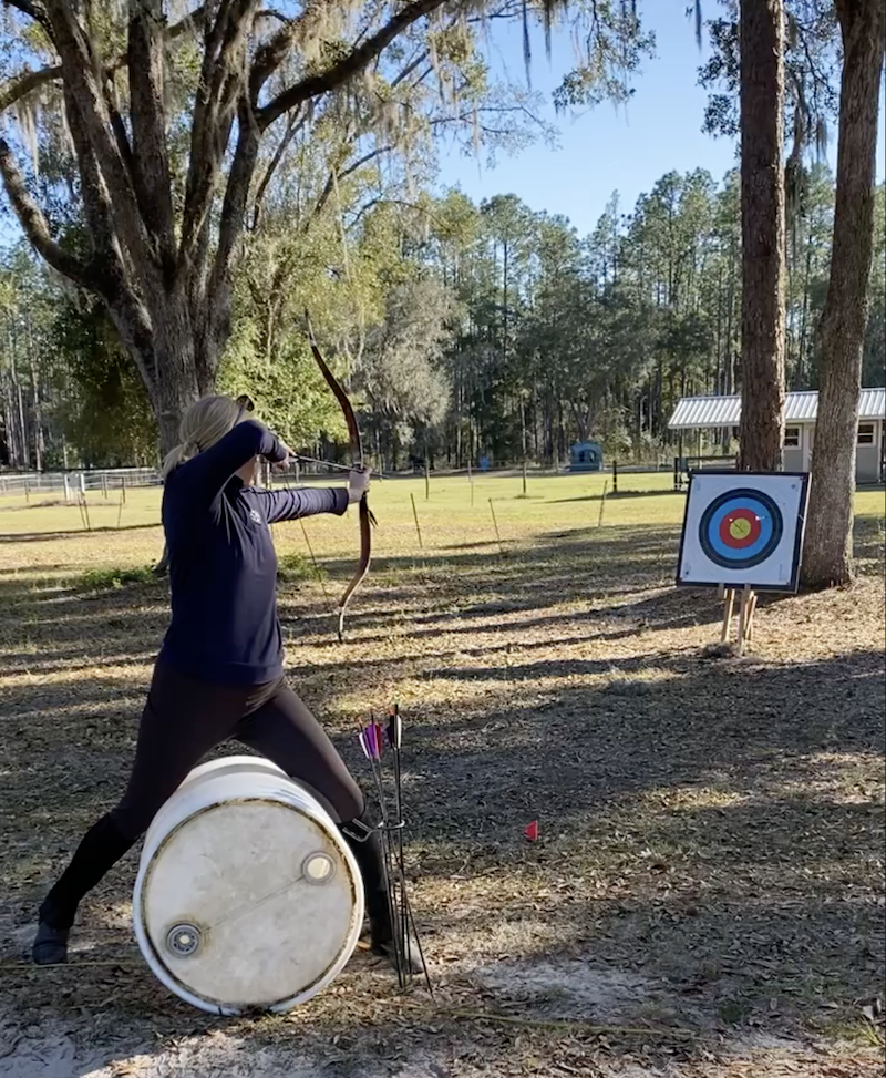 mounted archery practice on a barrell
